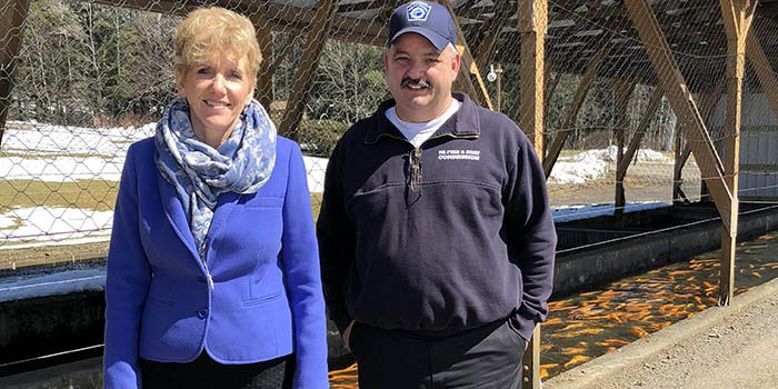 County Executive and hatchery manager stand near trout pools at Corry State Fish Hatchery