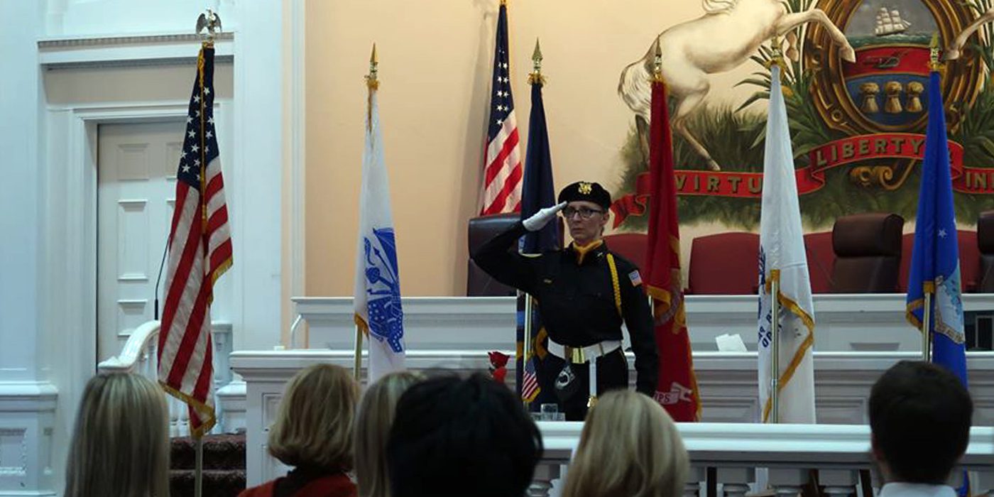 A female veteran salutes during a Veterans Day ceremony